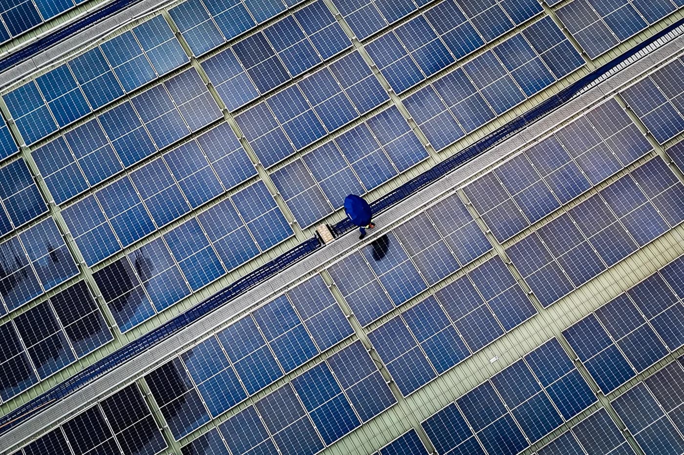 Fileiras de módulos fotovoltaicos sobre a cobertura de uma instalação industrial